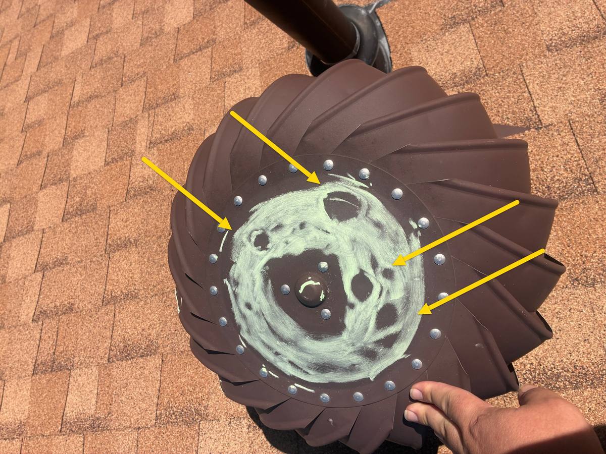 Hail dents on a metal turbine roof vent, circled in chalk with arrows during an SMI Roofing inspection