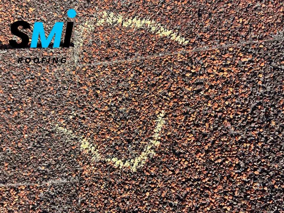 Close-up of a hail impact circled in chalk on an asphalt shingle during an SMI Roofing inspection in the Russellville, Arkansas area