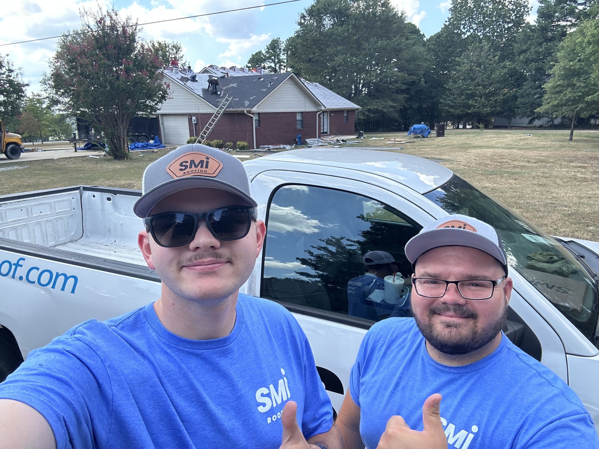 Two SMI Roofing team members at an active roof replacement jobsite